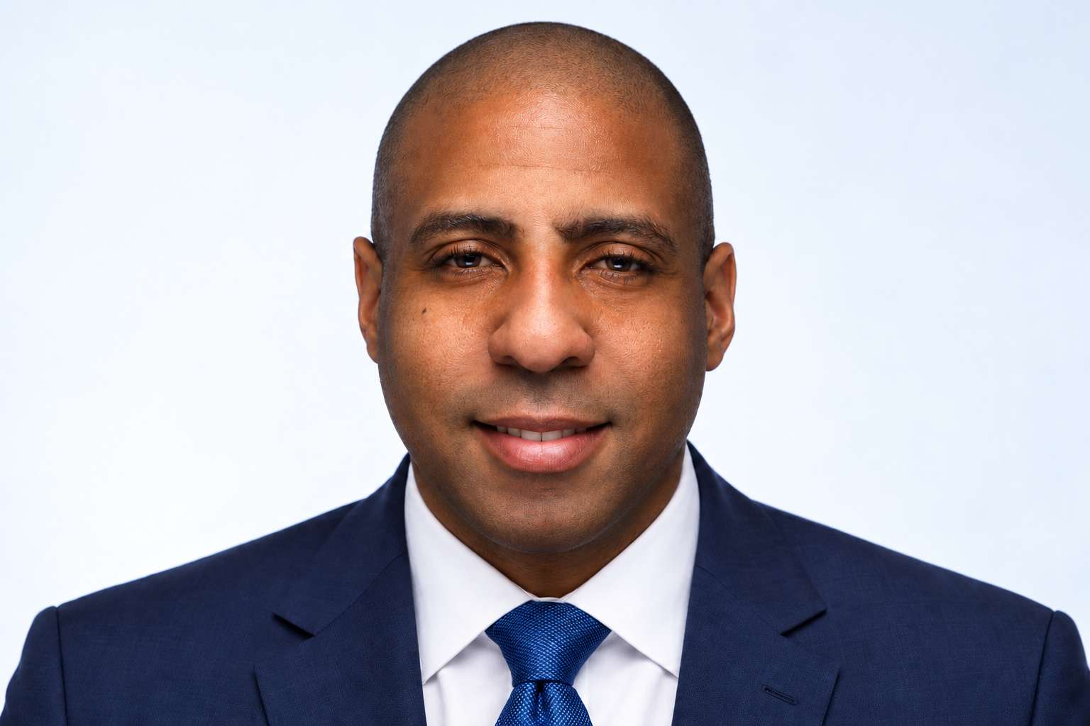 AI-generated professional portrait of Jamin Camp smiling in a navy suit and blue tie.